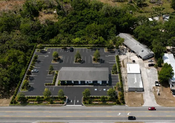 an aerial view of residential houses with outdoor space and parking