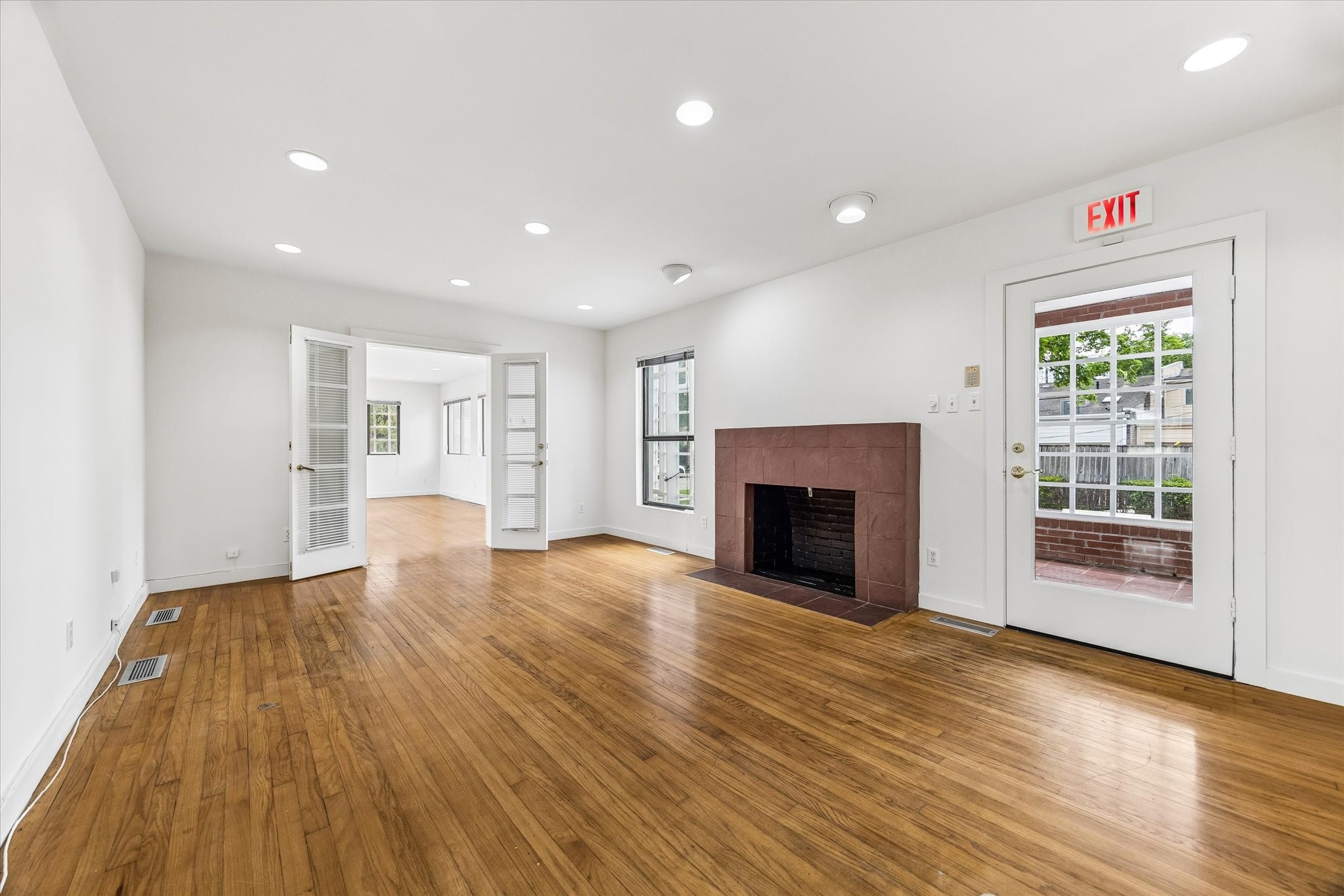 2402 Commonwealth Street Houston, TX 77006 - Photo 27 of 45 a view of an empty room with wooden floor fireplace and a window
