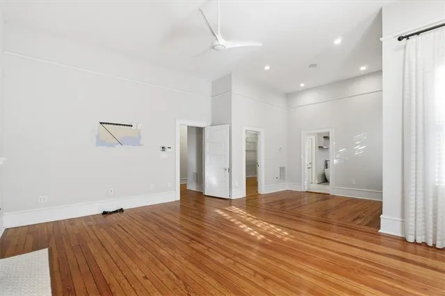a view of empty room with wooden floor and fireplace