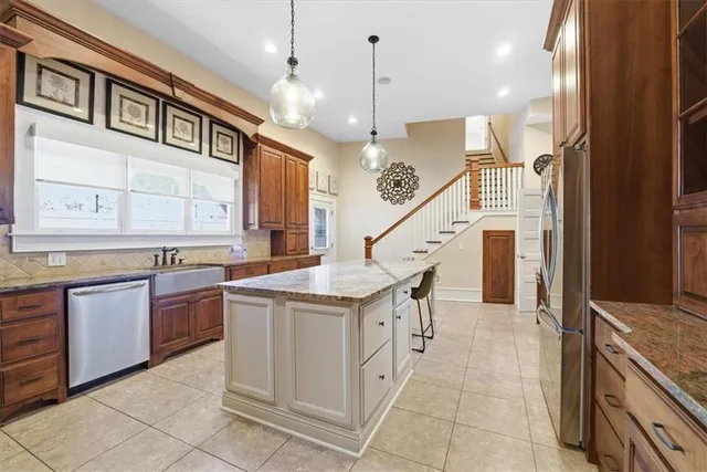a kitchen with stainless steel appliances granite countertop a stove refrigerator and cabinets