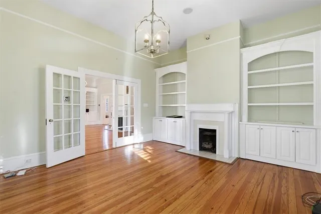 a view of a livingroom with a fireplace wooden floor and a ceiling fan