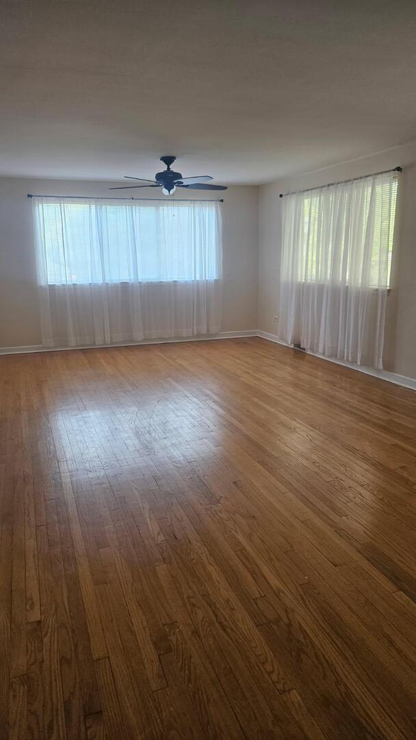 611 Wesley Avenue, Unit 1 Evanston, IL 60202 - Photo 2 of 8 an empty room with wooden floor and windows