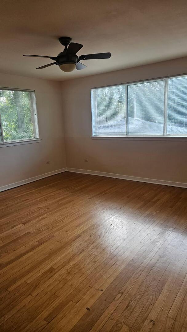611 Wesley Avenue, Unit 1 Evanston, IL 60202 - Photo 6 of 8 an empty room with wooden floor and windows
