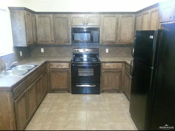 a kitchen with stainless steel appliances granite countertop a refrigerator and a stove