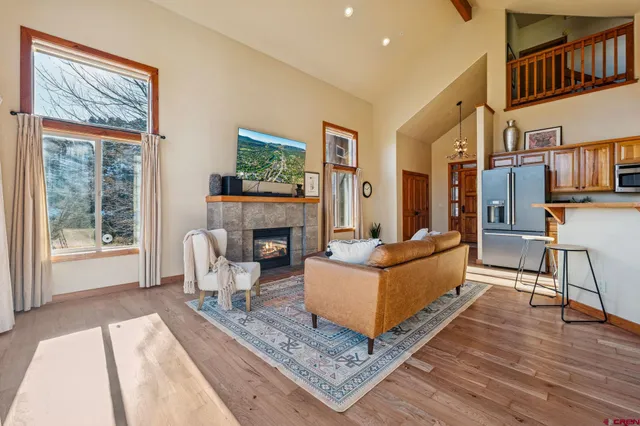 a living room with furniture a large window and a fireplace