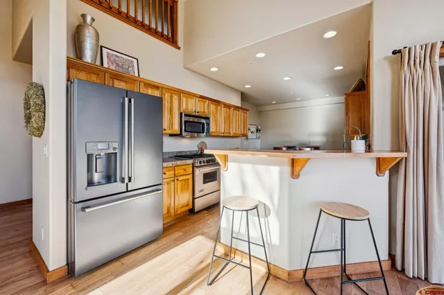 a kitchen with stainless steel appliances kitchen island granite countertop a refrigerator and microwave