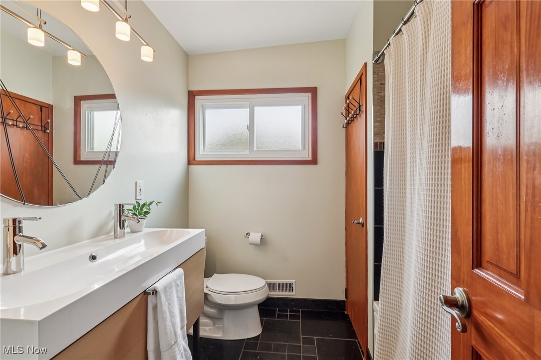 6568 Sherborn Road Parma Heights, OH 44130 - Photo 18 of 47 Full bath featuring toilet, vanity, curtained shower, and baseboards