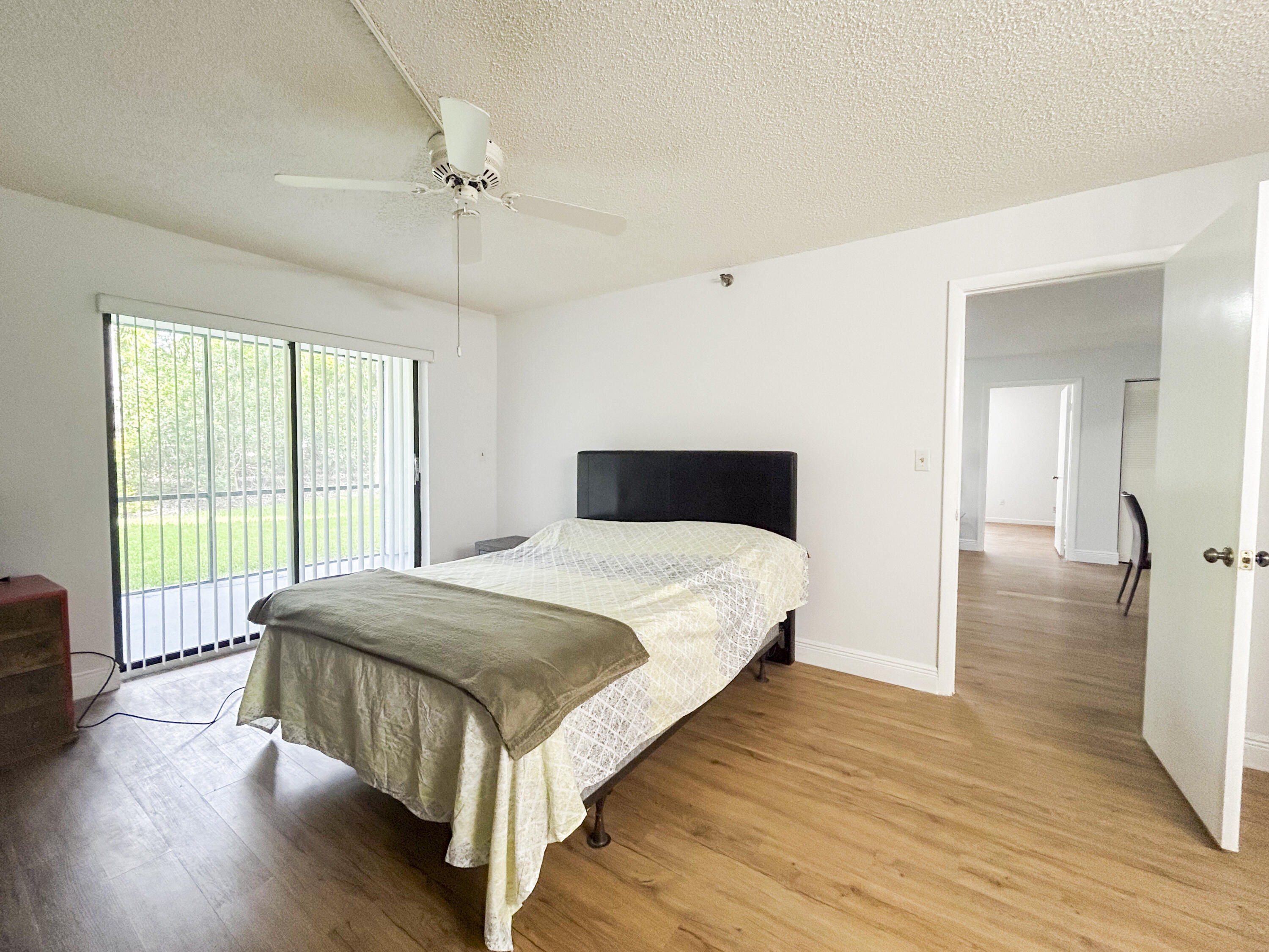 9235 Southwest 8th Street, Unit 114 Boca Raton, FL 33428 - Photo 13 of 18 a bedroom with a bed and a large window