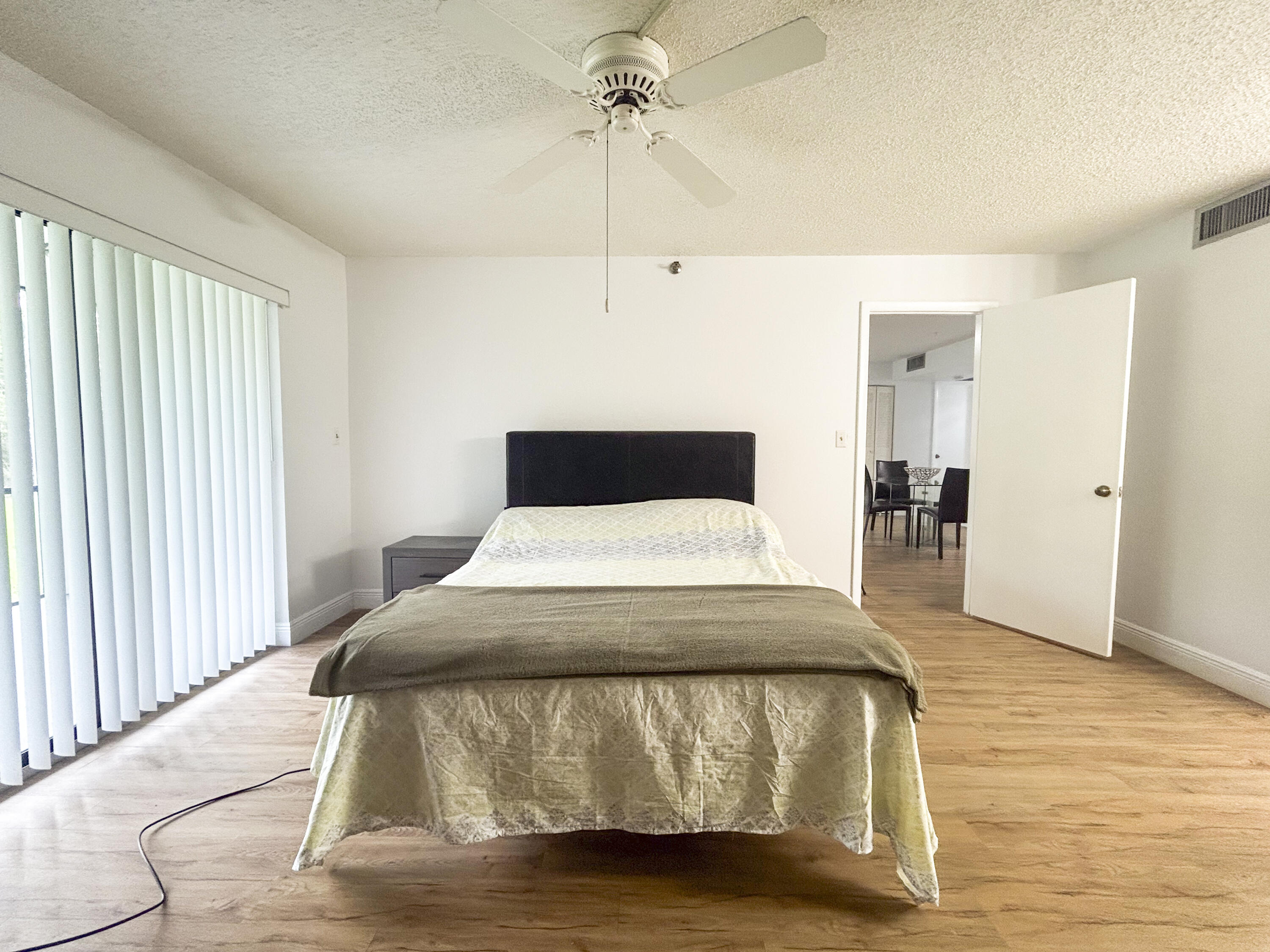 9235 Southwest 8th Street, Unit 114 Boca Raton, FL 33428 - Photo 14 of 18 a bedroom with a bed and wooden floor