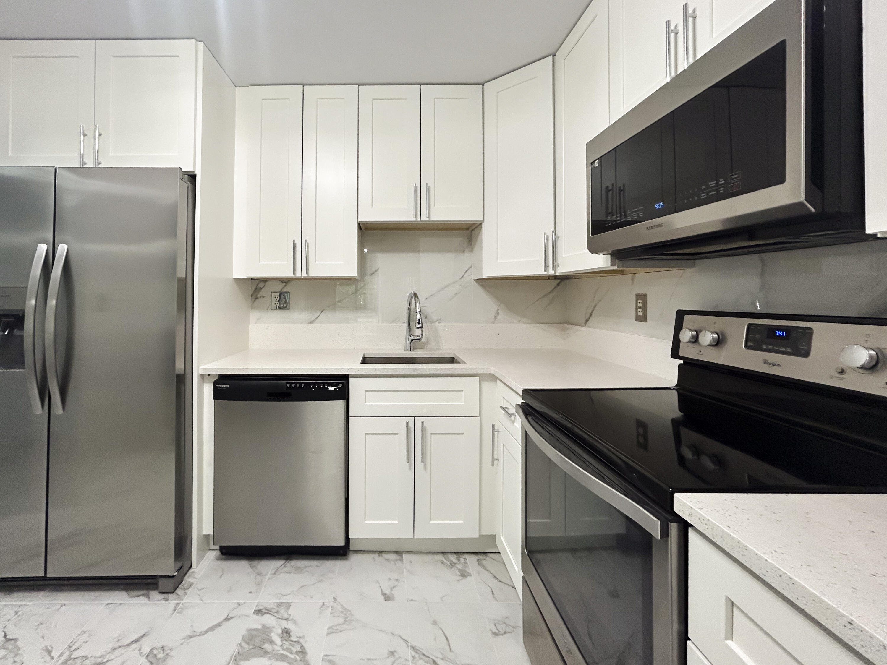 9235 Southwest 8th Street, Unit 114 Boca Raton, FL 33428 - Photo 6 of 18 a kitchen with stainless steel appliances granite countertop a refrigerator stove top oven and sink