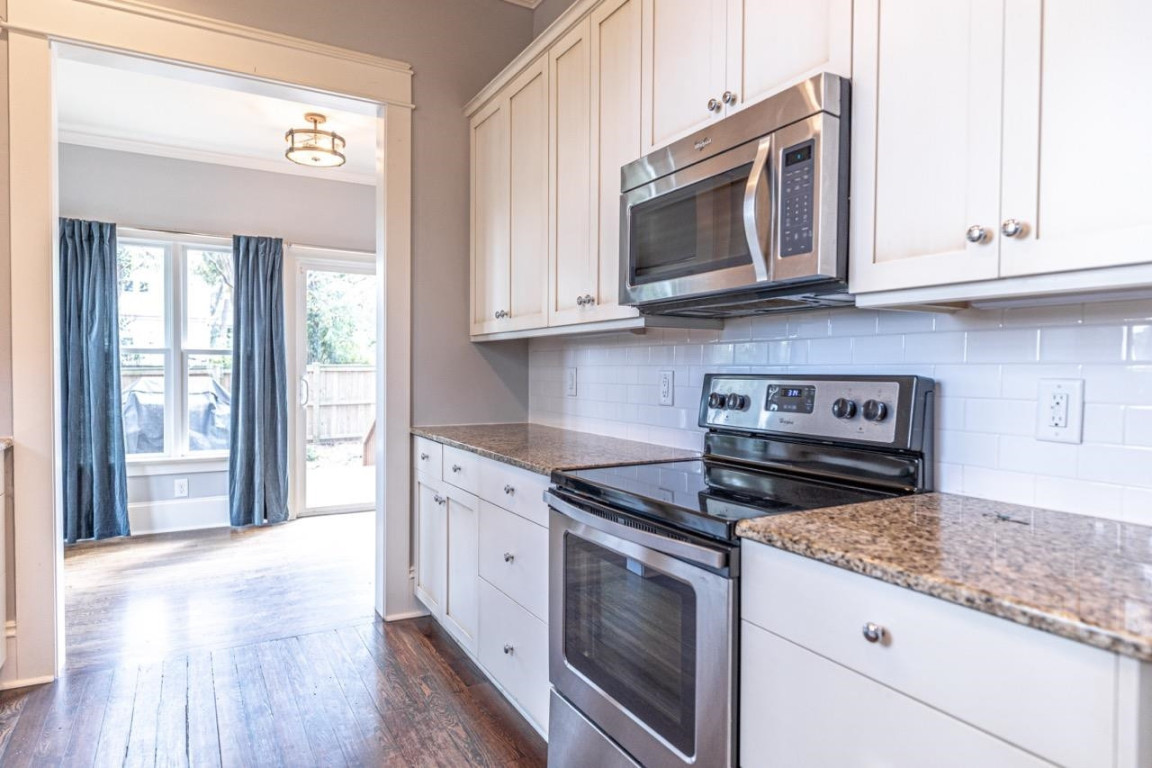 Undisclosed Address Raleigh, NC 27605 - Photo 12 of 29 a kitchen with granite countertop a stove and a microwave