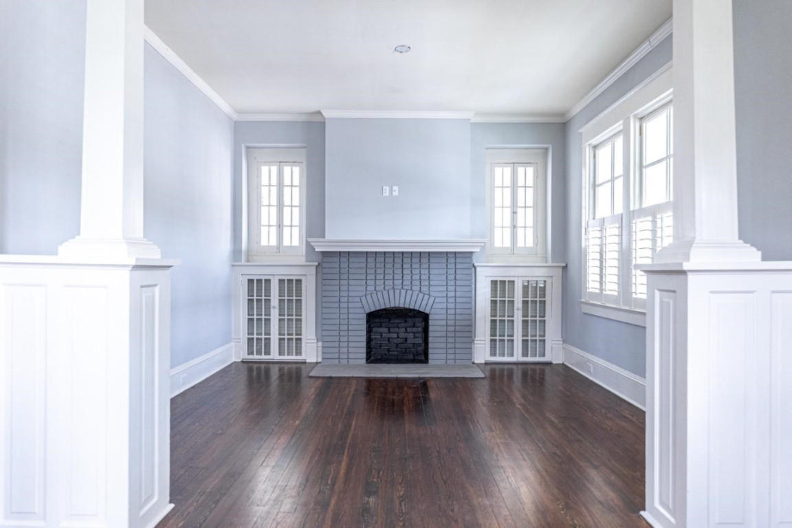 Undisclosed Address Raleigh, NC 27605 - Photo 3 of 29 an empty room with wooden floor fireplace and windows