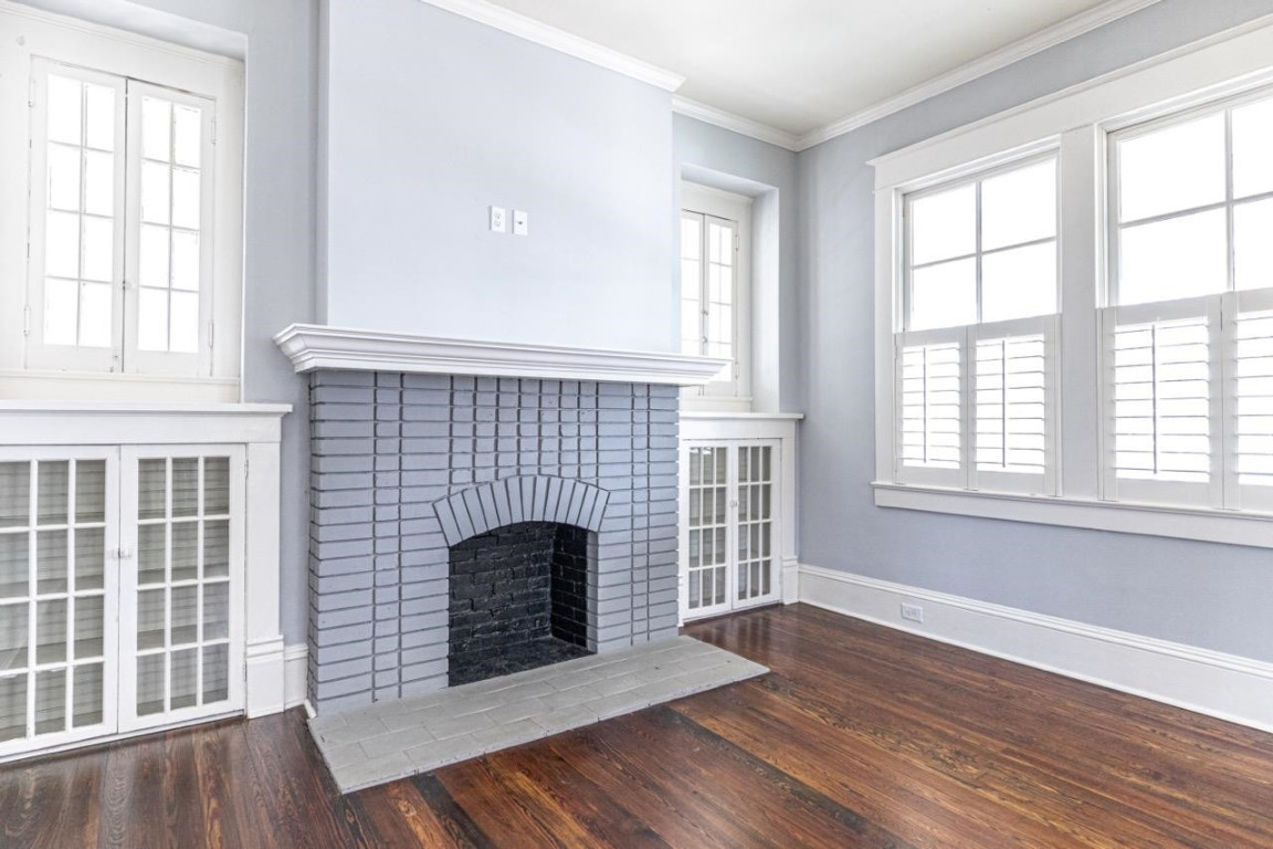 Undisclosed Address Raleigh, NC 27605 - Photo 4 of 29 an empty room with wooden floor and fireplace