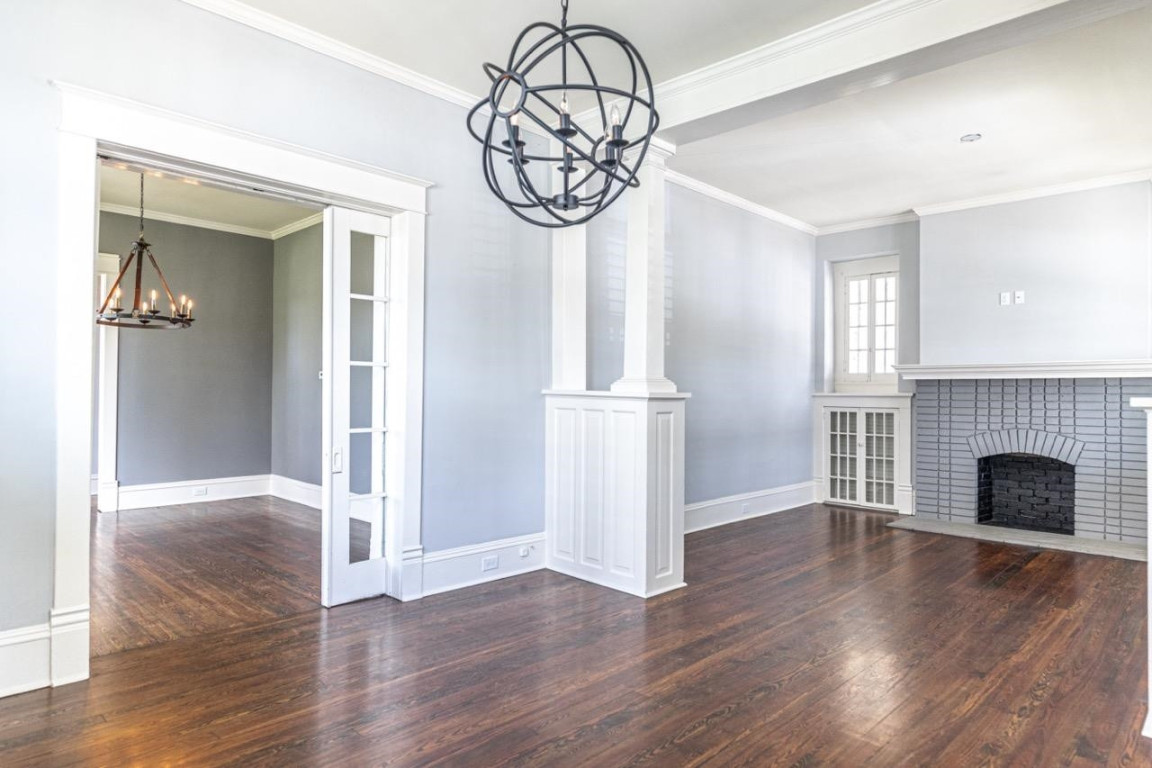 Undisclosed Address Raleigh, NC 27605 - Photo 8 of 29 an empty room with wooden floor fireplace and windows