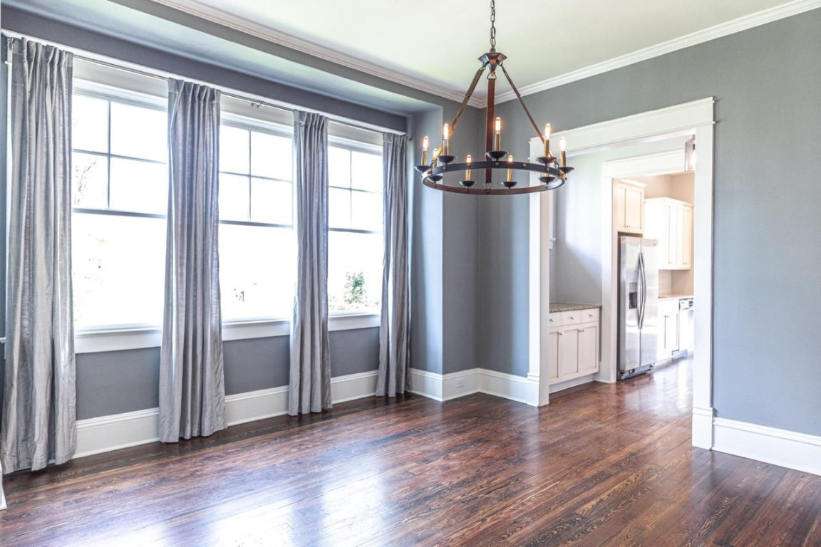 Undisclosed Address Raleigh, NC 27605 - Photo 10 of 29 a view of a hallway with wooden floor and a chandelier