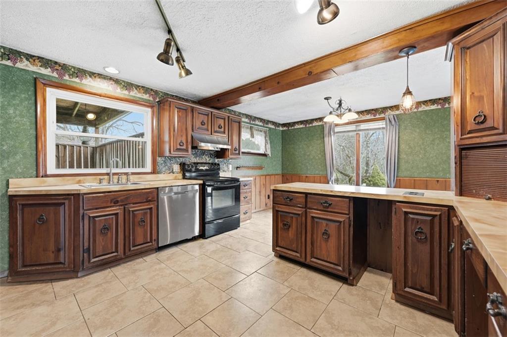 192 Yellow Creek Road Harmony, PA 16037 - Photo 11 of 41 a large kitchen with stainless steel appliances granite countertop a stove and cabinets