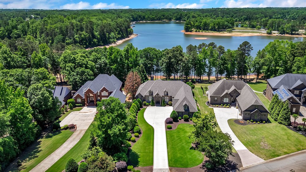 114 Willowbend Drive Anderson, SC 29621 - Photo 4 of 50 This aerial view showcases a vibrant community nestled by a serene lake, surrounded by lush green landscapes.