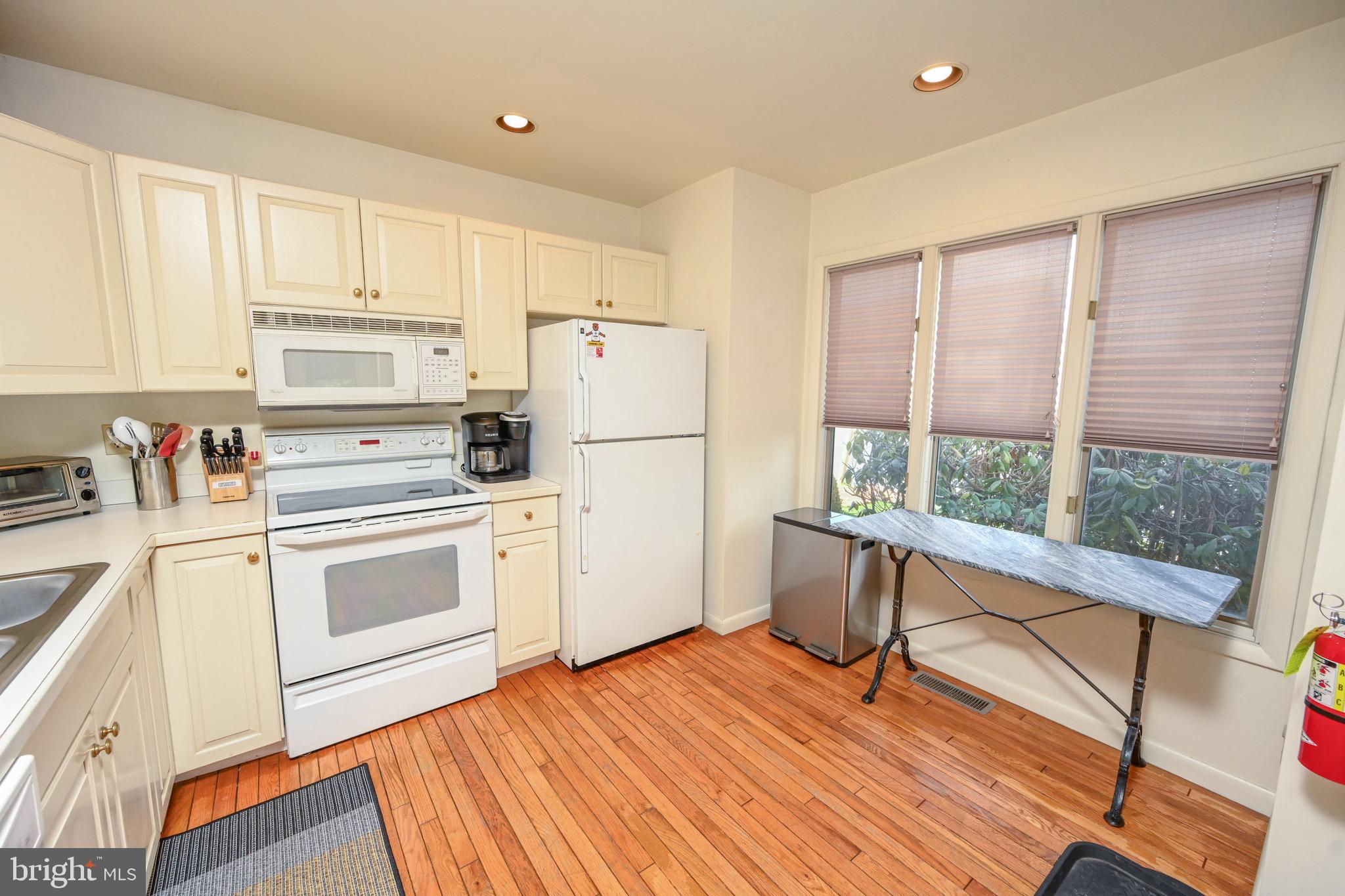 257 Marsh Hill Road, Unit 1 McHenry, MD 21541 - Photo 7 of 50 a kitchen with a refrigerator stove and white cabinets with wooden floor