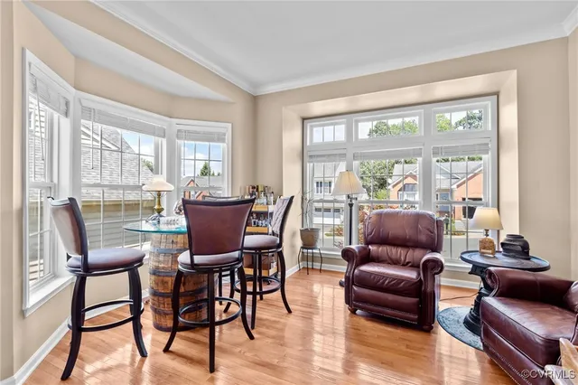 a dining room with furniture and large windows