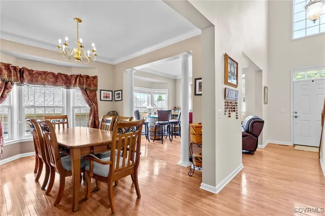 a view of a a dining room with furniture window and wooden floor