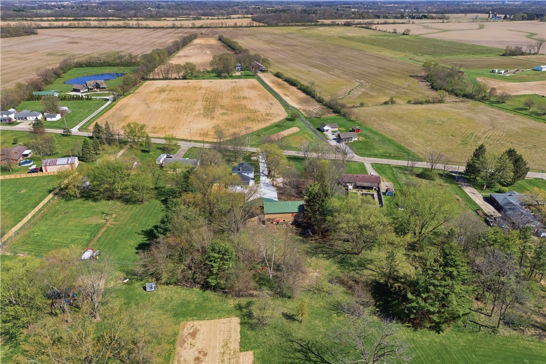 3190 Rebert Pike Springfield, OH 45502 - Photo 44 of 48 An aerial view showcases expansive cultivated fields and scattered residential properties under a clear sky.