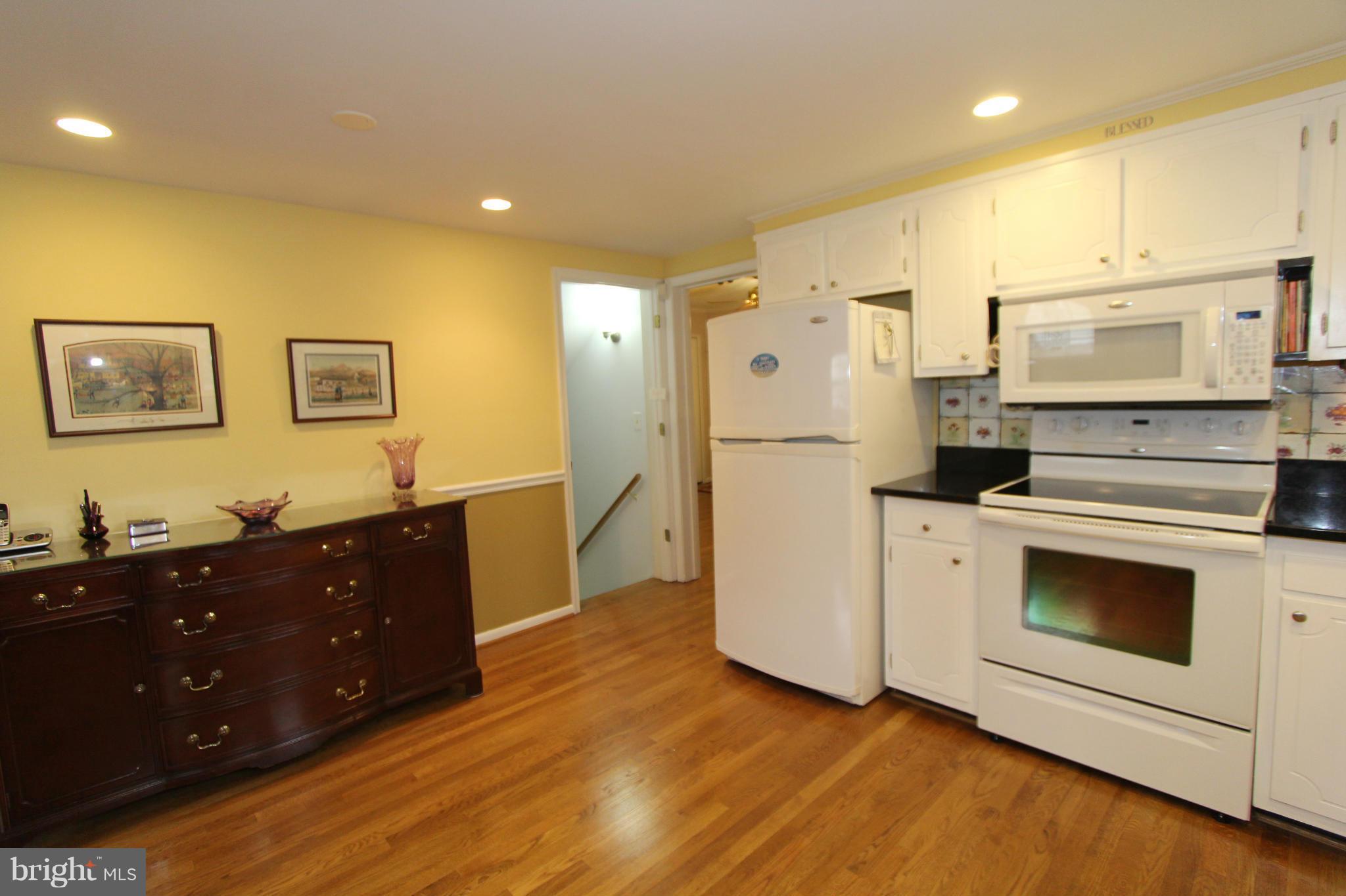 2000 Byrd Road Vienna, VA 22182 - Photo 10 of 30 a kitchen with stainless steel appliances white cabinets and wooden floor