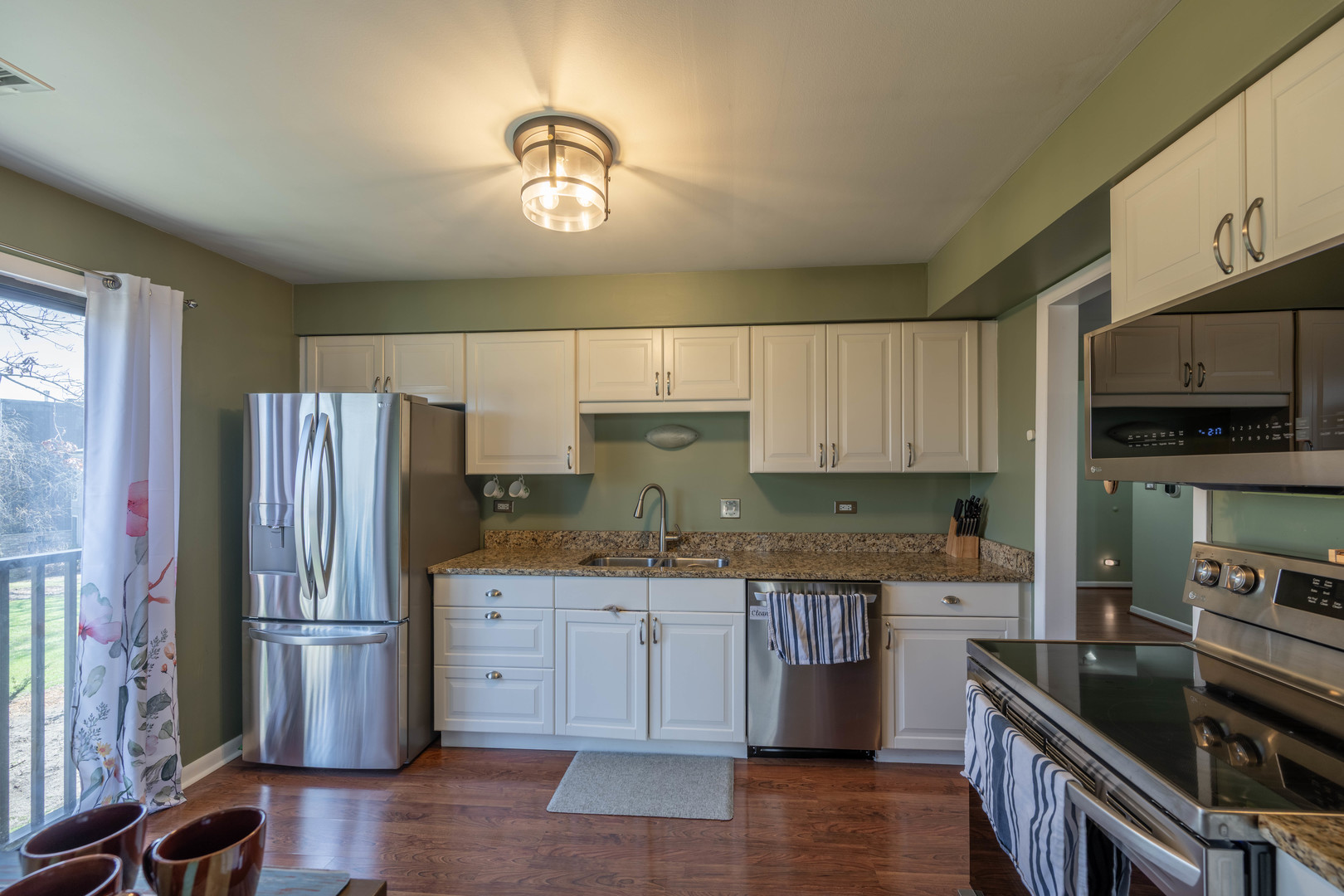 1495 South County Farm Road, Unit 23 Wheaton, IL 60189 - Photo 16 of 21 a kitchen with stainless steel appliances granite countertop a refrigerator a stove a sink dishwasher and white cabinets with wooden floor