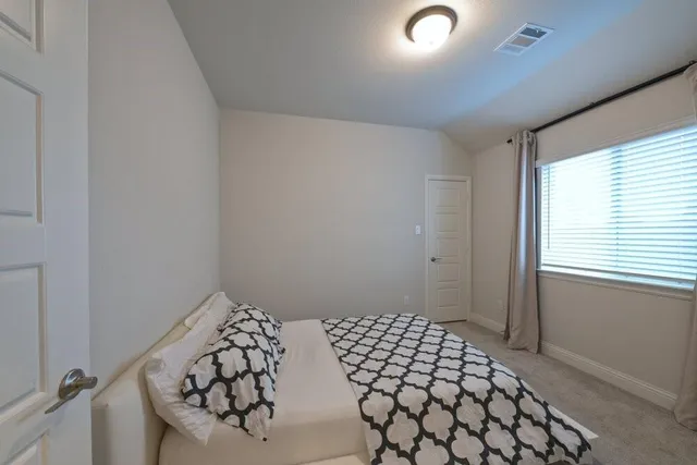 a bedroom with a bed and a window