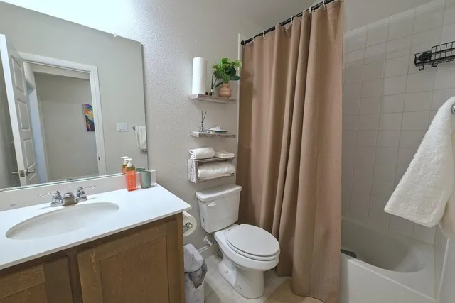 a bathroom with a sink a toilet a mirror and shower