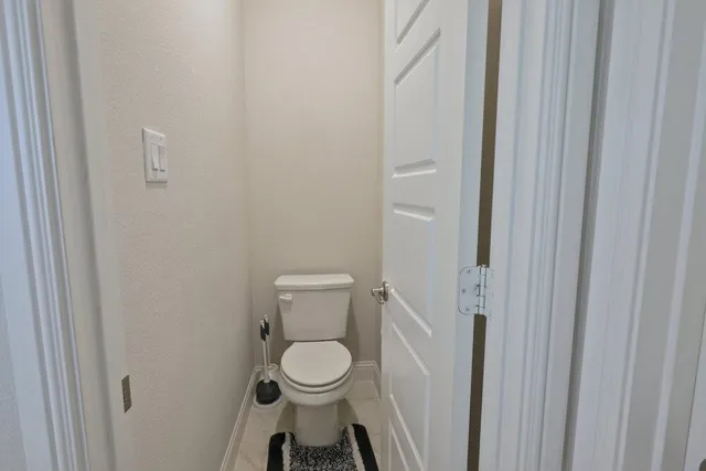 a white toilet sitting next to a white cabinet