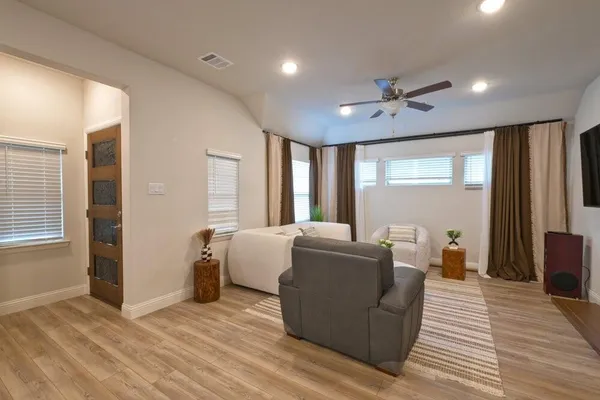 a living room with furniture and a wooden floor