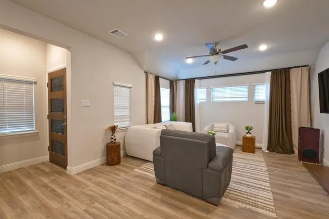 a living room with furniture and a wooden floor