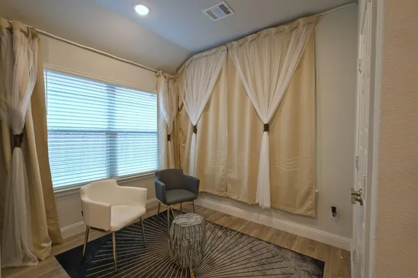 a view of a room with a window and furniture