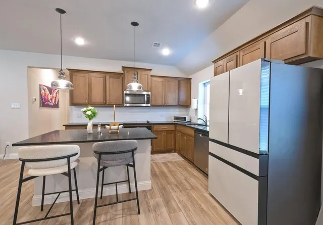 a kitchen with kitchen island a counter top space appliances and cabinets