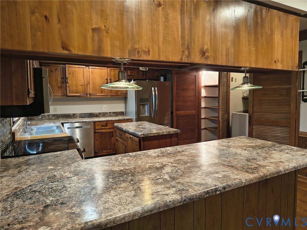 2174 Grubby Road Halifax, VA 24558 - Photo 24 of 25 a kitchen with kitchen island granite countertop wooden cabinets and a refrigerator