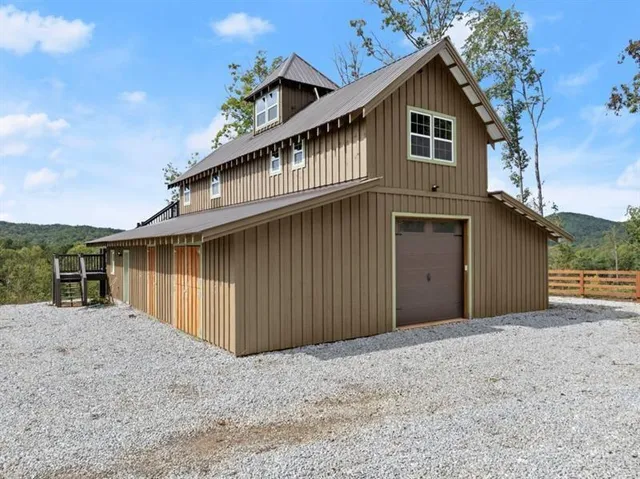 an aerial view of residential houses with outdoor space and trees