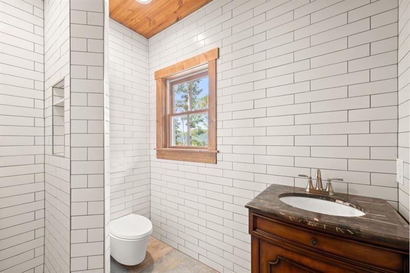 144 David Drive Tiger, GA 30576 - Photo 36 of 71 a bathroom with a granite countertop toilet a sink a mirror and a shower