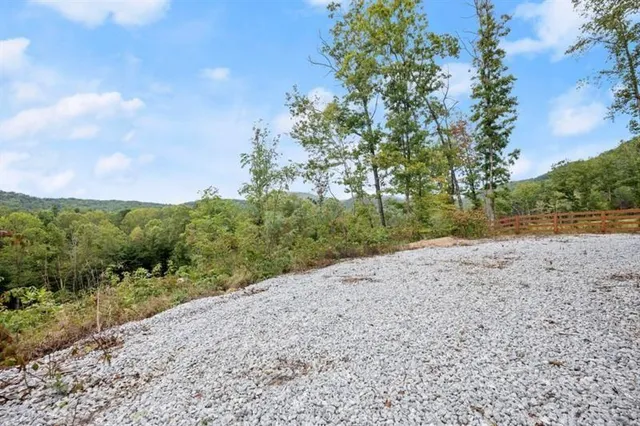 a open kitchen with granite countertop a sink dishwasher a stove and white cabinets with wooden floor