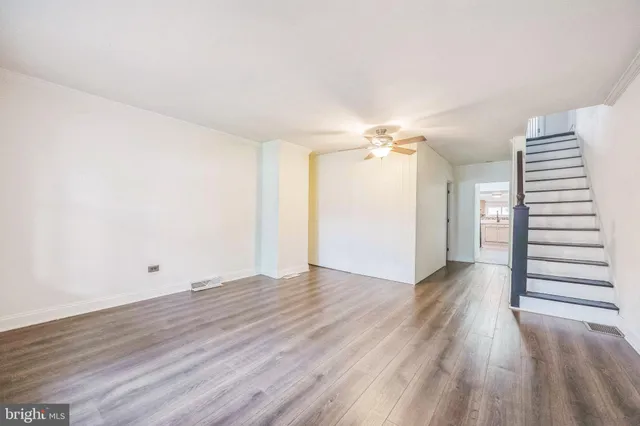 a view of a room with wooden floors and stairs