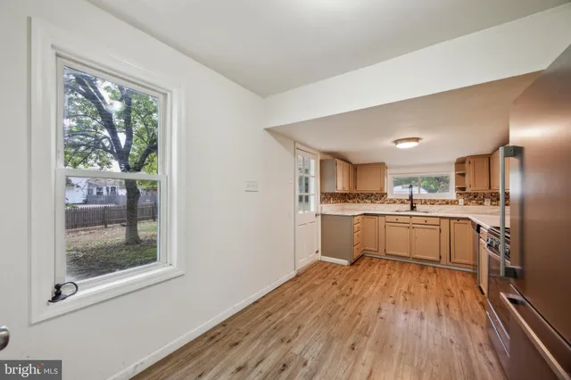 a kitchen with a refrigerator and wooden floor
