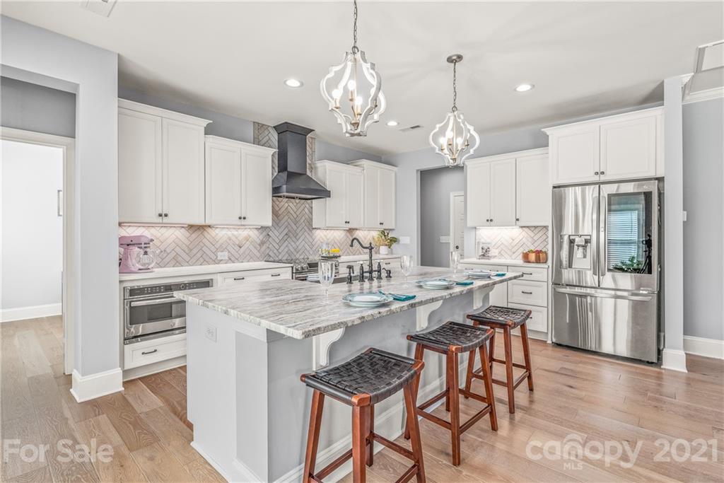 2701 Walker Road Matthews, NC 28105 - Photo 7 of 32 a kitchen with stainless steel appliances kitchen island granite countertop a sink a stove a refrigerator and island with wooden floor
