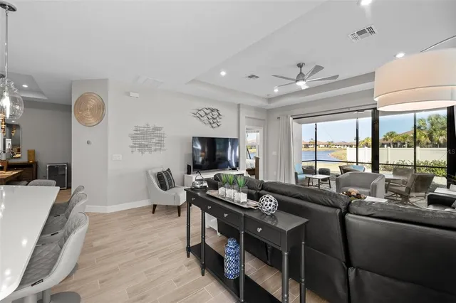 a living room with furniture flat screen tv and a large window