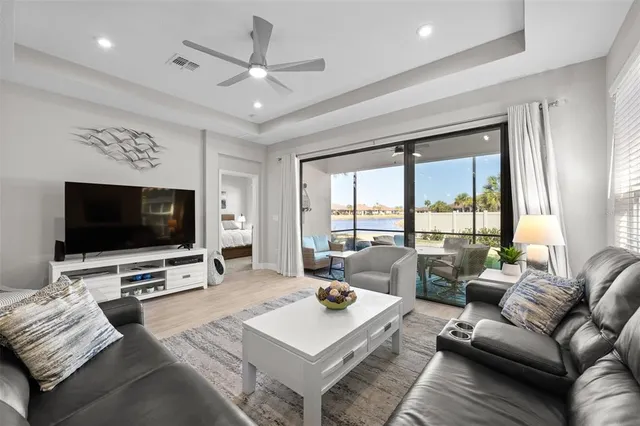 a living room with furniture a flat screen tv and a large window