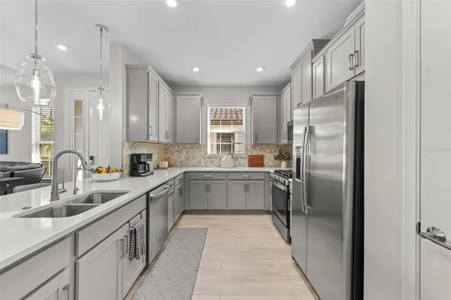 a kitchen with a sink refrigerator and cabinets