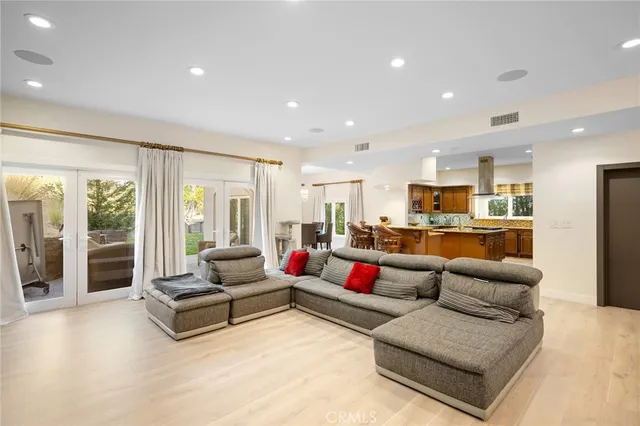 a living room with furniture kitchen view and a large window