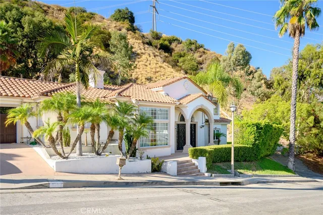 a view of a white house with a palm tree