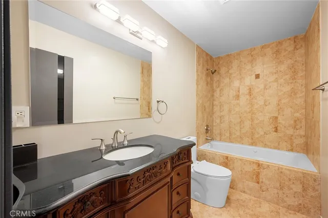 a bathroom with a granite countertop sink toilet a mirror and shower