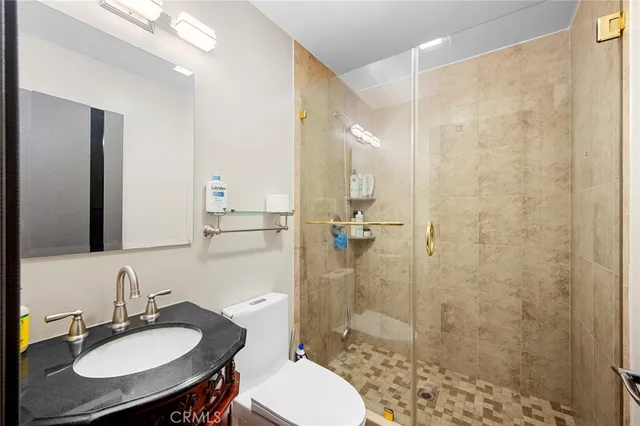 a bathroom with a sink toilet a mirror and shower