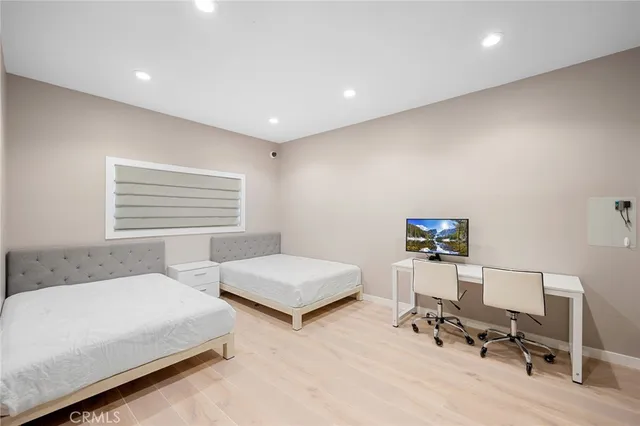 a bedroom with two beds and a desk