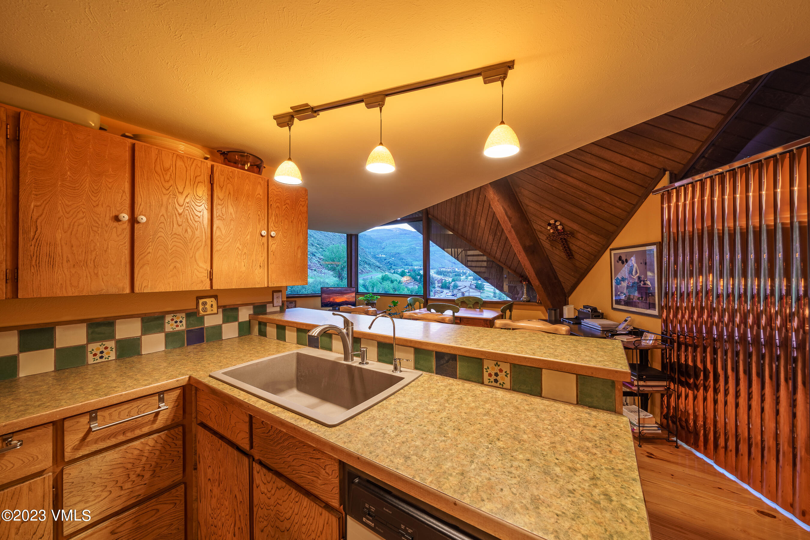 1400 Lions Ridge Loop, Unit A2 Vail, CO 81657 - Photo 29 of 38 a kitchen with a sink a counter and chairs
